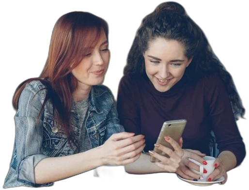 Two women smiling while looking at a phone together